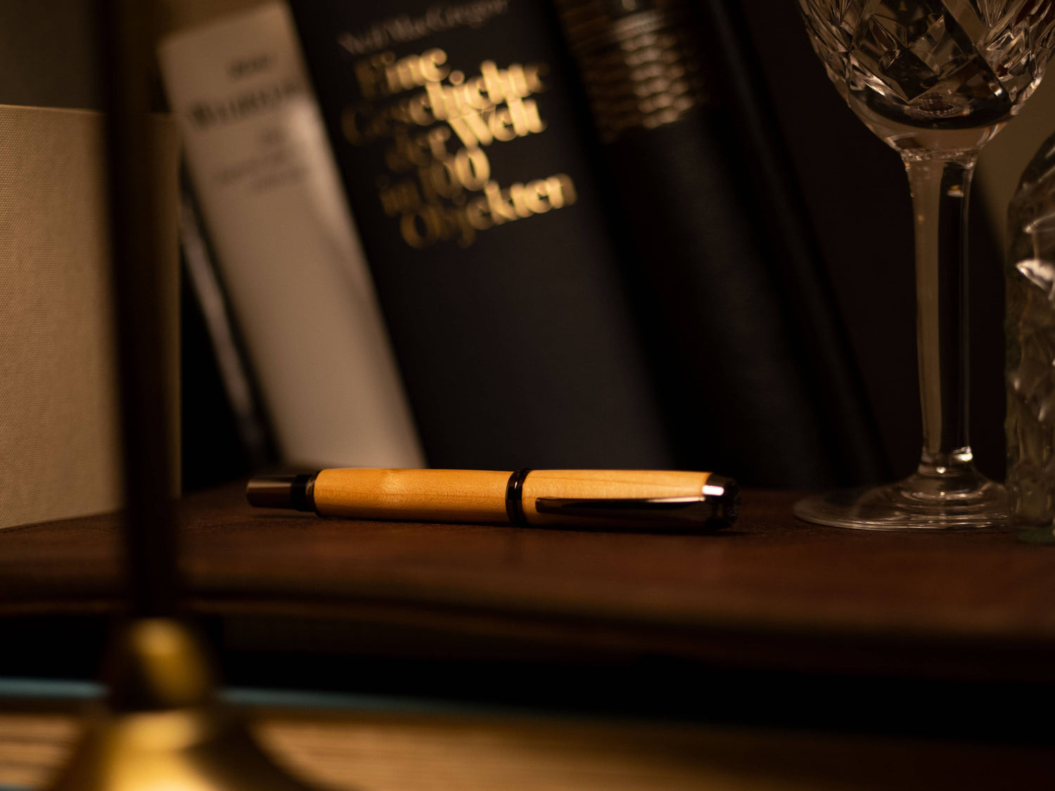 Avi Füllfederhalter Kirschholz liegend vor Büchern