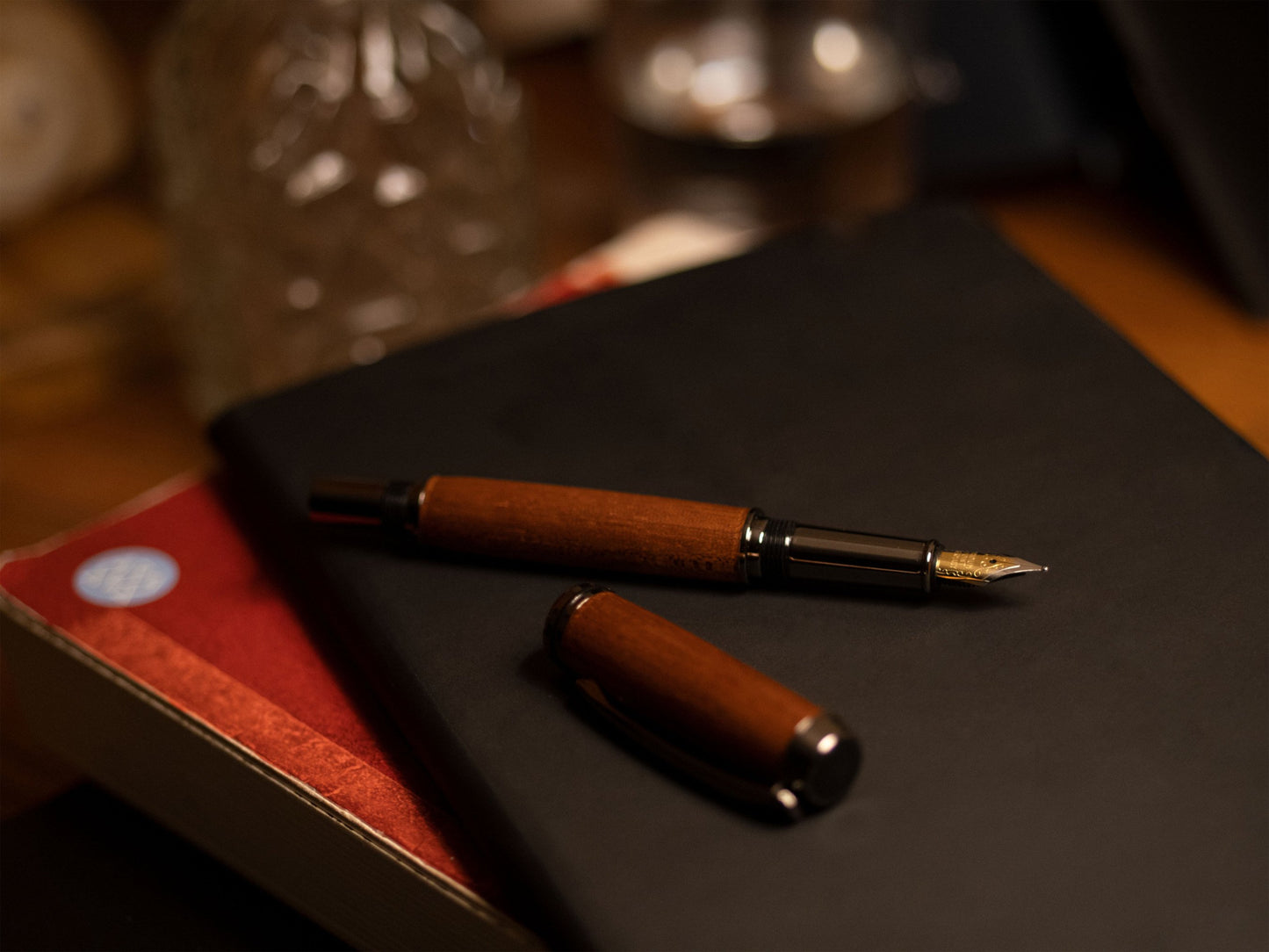 Era Füllfederhalter Mahagoni, offene Kappe, auf Büchern liegend