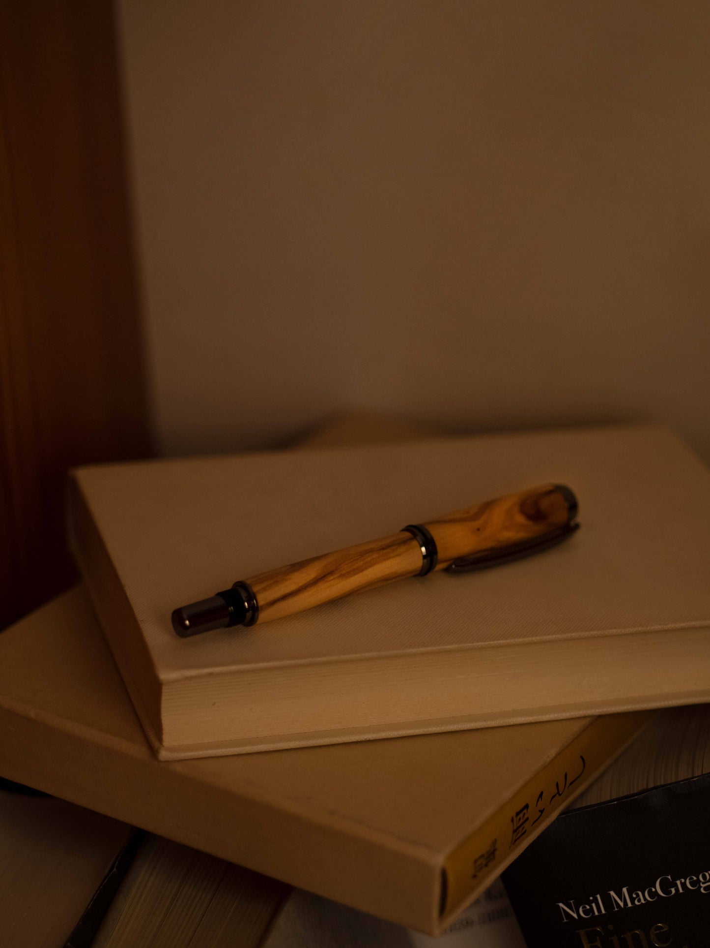 Olia Füllfederhalter Olivenholz liegend auf Buch, geschlossene Kappe
