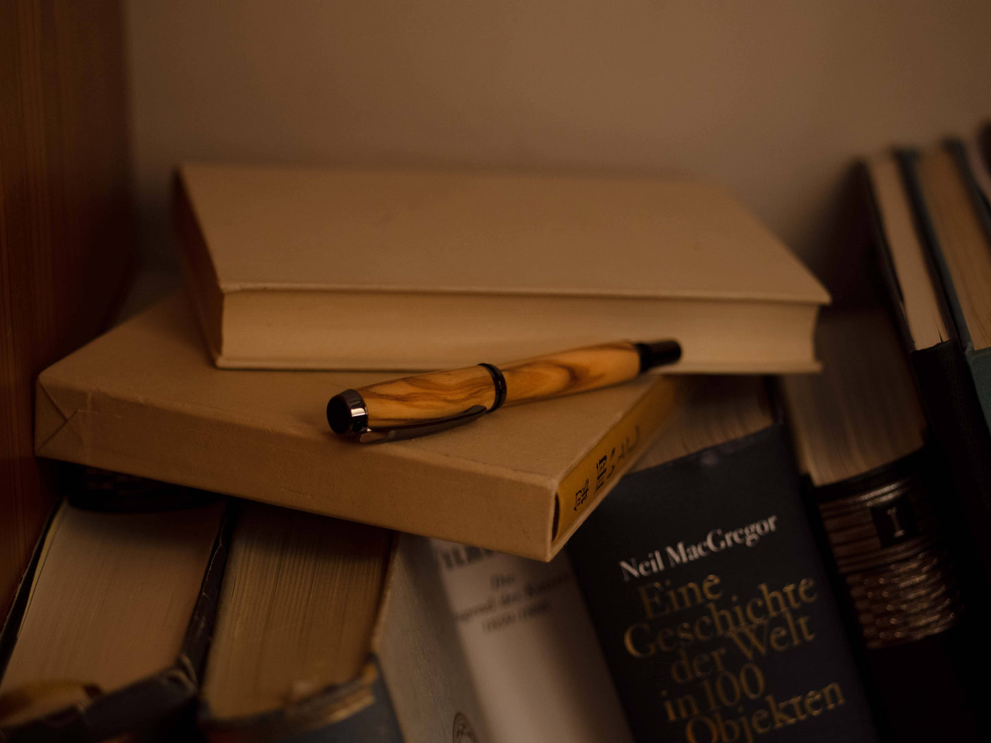 Olia Tintenroller Olive liegend auf Büchern